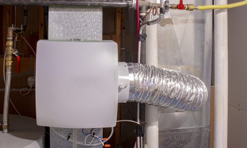 A home humidifier attached to the return duct with a bypass connection to the supply hot air duct.