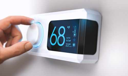 Thermostat, Home Energy Saving Hand turning a home thermostat knob to set temperature on energy saving mode. fahrenheit units. Composite image between a photography and a 3D background.